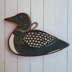 a metal duck on a white wooden background