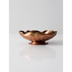 a metal bowl sitting on top of a white table