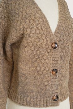 a woman's sweater with buttons on the front