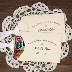 two envelopes on a doily with white ribbons