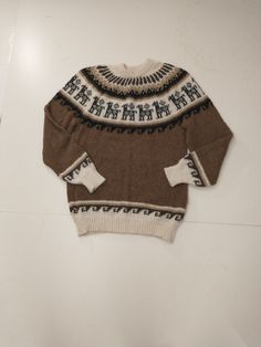 a brown and white sweater sitting on top of a table