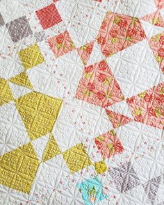 a close up of a quilt with many different colored squares on the top and bottom