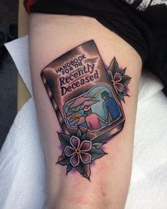 a tattoo on the leg of a woman with an image of a book in it