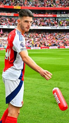 a soccer player is on the field with his foot in the air as he prepares to kick a ball