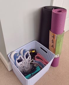 there are many pairs of shoes and yoga mats in the basket next to each other