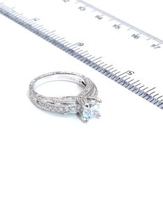 an engagement ring sitting on top of a ruler