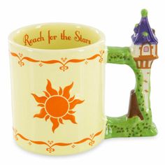 a coffee mug with a small house on the front and an orange sun in the middle