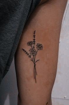 a black and white photo of a flower tattoo on the left upper half of the arm