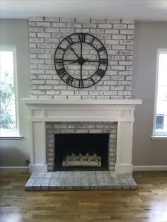 a clock mounted on the wall above a fireplace