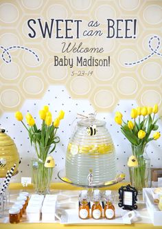 a baby shower party with yellow flowers in vases and welcome sign on the wall