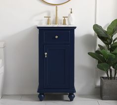 a white toilet sitting next to a blue cabinet with a mirror on top of it