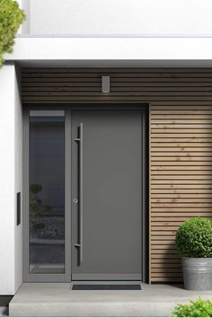 an entrance to a building with two potted plants next to it and the number 28 on the door