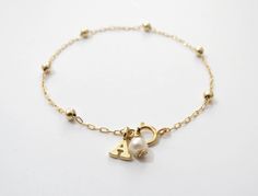 "Simple. Chic. Minimalist™ A perfectly dainty, lightweight, most feminine gold filled bracelet. This bracelet is made with 14k gold filled dots measure 3mm each and 14K gold filled chain, personalized with a tiny 14K gold plated initial and wire wrapped pearl for an extra classy look. Also can be wear as an anklet- simply choose large size at checkout. 〰 All parts are made with top quality materials! Also available with sterling silver or 14K Rose gold filled Model is wearing 6.5\" length This b Minimalist Gold Pearl Bracelet With Delicate Chain, Dainty Hypoallergenic Name Bracelet, Dainty 14k Gold Beaded Bracelets, Dainty 14k Gold-filled Name Bracelet, Dainty Name Bracelet For Bridesmaid Gift, Dainty Personalized Gold Pearl Bracelet, Minimalist 14k Gold-filled Pearl Bracelet, Dainty 14k Gold Filled Name Bracelet, Gold Personalized Dainty Pearl Bracelet