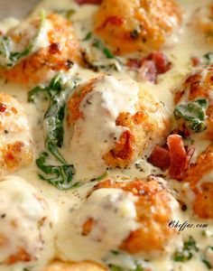 a pizza with meatballs covered in cheese and spinach