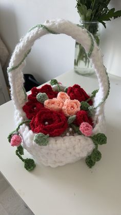 a crocheted basket with flowers in it