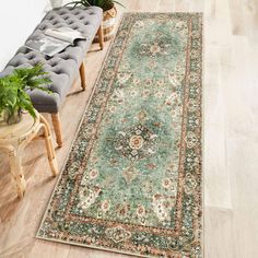 a large green rug on the floor next to a bench and potted houseplant