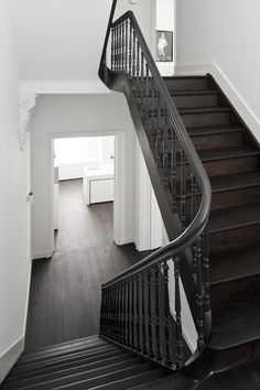 a black and white staircase with wooden handrails