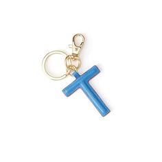 a blue cross keychain is shown on a white surface with a gold chain