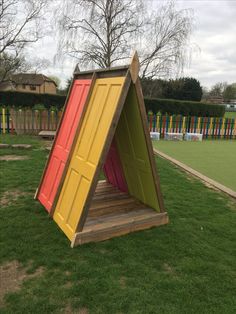 an outdoor play area with colorful doors on the grass