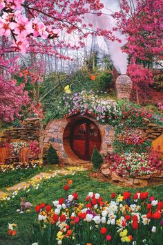 an image of a garden with flowers and a hobbot in the middle that is surrounded by trees