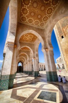 the inside of an ornate building with arches and tiled flooring, looking up into the sky