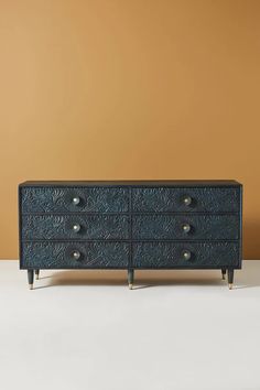 a black dresser with gold handles and drawers