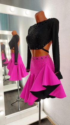 a woman's pink skirt with black sequins on it in front of a mirror