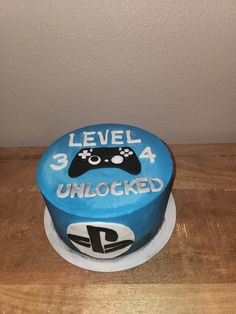 a blue cake with a controller on it that says level 4 unlocked in white lettering