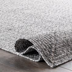 a close up view of a rug on the floor with wood floors in the background