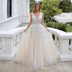 a woman in a wedding dress standing on a balcony with her hands on her hips