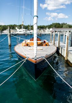 a sailboat docked at a dock with other boats in the water