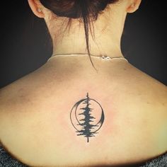 the back of a woman's neck with a pine tree tattoo on it