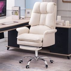 a white office chair sitting in front of a computer desk