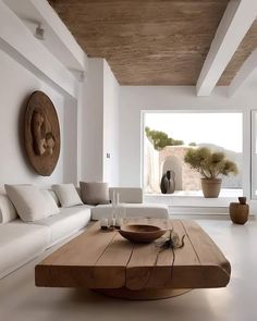 a living room filled with furniture and a large wooden table in front of a window