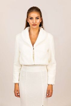 a woman wearing a white coat and skirt