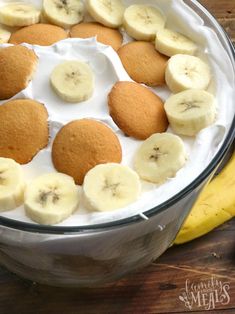 a bowl filled with banana slices and cookies on top of a wooden table next to a banana