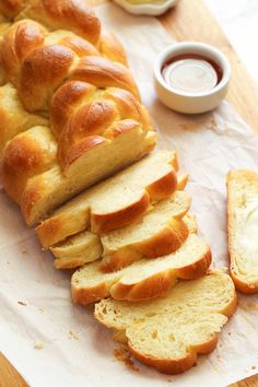 a loaf of bread sitting on top of a cutting board next to sliced bread and butter