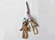 two stuffed animals are hanging on a white wall and one is wearing a purple hat