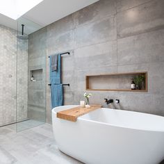 a large white bath tub sitting next to a walk in shower