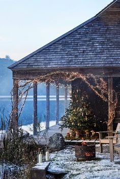 a gazebo covered in snow next to a lake