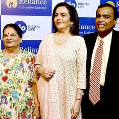 three people standing next to each other in front of a blue and white wall with the words reliance written on it