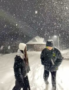 two people are walking through the snow