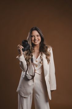 a woman in white is holding a camera