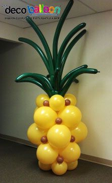 a balloon sculpture made to look like a pineapple is on display in an office cubicle