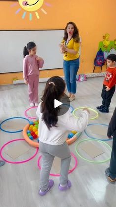 a group of young children playing with toys in a circle on the floor, while an adult watches