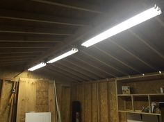 an unfinished room with some lights on the ceiling and shelves in the back ground area