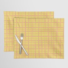 two place mats with forks and spoons on them, one yellow checkered cloth