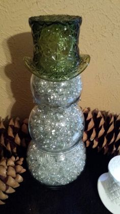 a stack of glass balls sitting on top of a table next to a cup and saucer