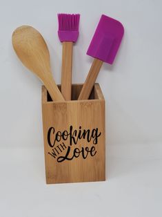 wooden utensils and spoons in a holder with the words cooking with love written on it