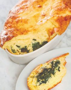 an omelet with spinach and cheese is on a plate next to another dish